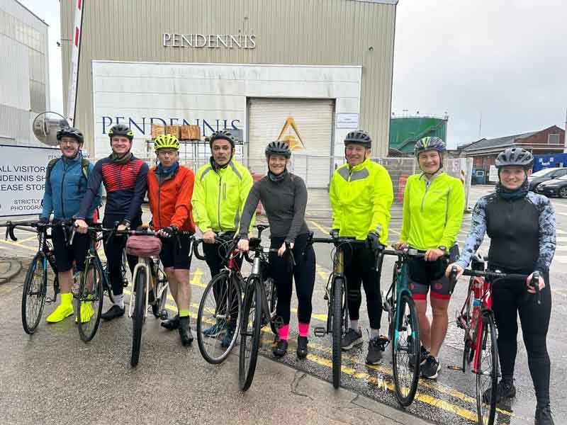 Group of cyclists from Pendennis Shipyard holding their bikes.